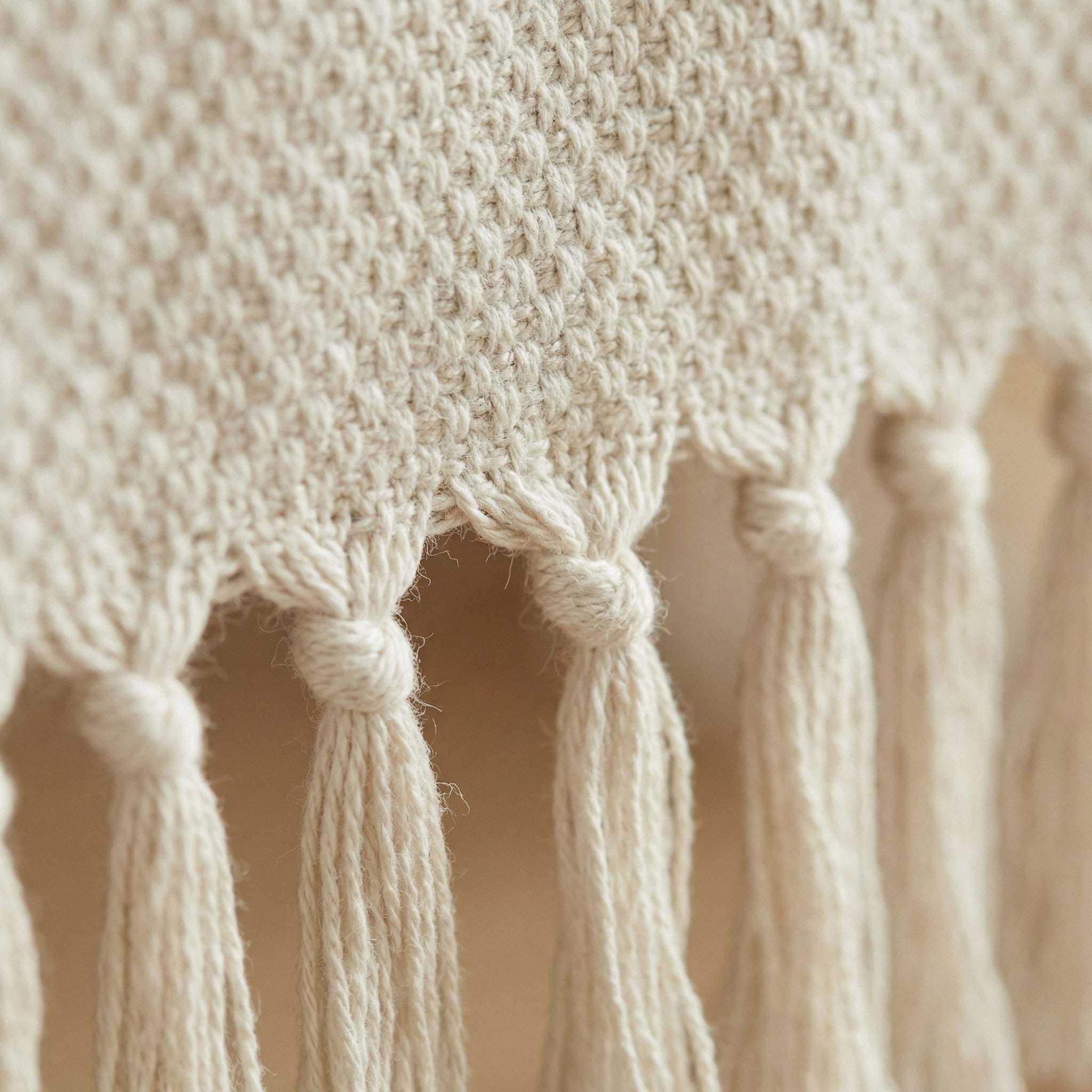 Close-up of the natural woven cotton texture and handmade tassels on a table runner