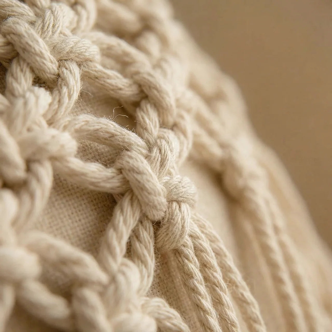Close-up of the textured hand-woven fabric and neat tassel knots on a boho pillowcase